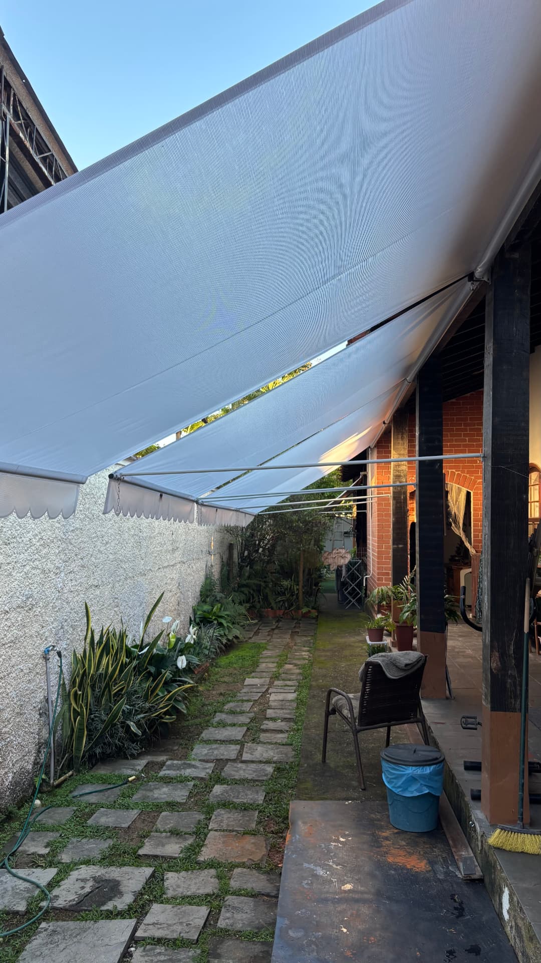 Cobertura retrátil em lateral de casa com jardim